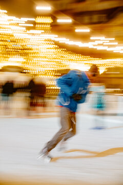 A person on an outdoor skating rink moves quickly on skates