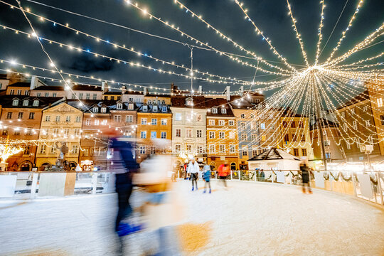 People go ice skating in the evening in the old European city