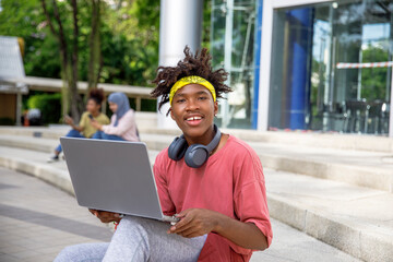Portrait of student with laptop in college campus