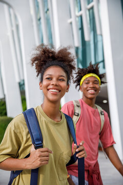 Happy university friends walking on campus