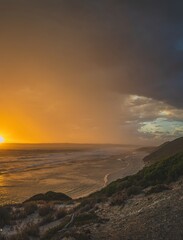 Golden sunset seascape with approaching thunderstorm clouds 