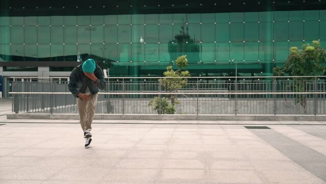 Happy hipster listen to hip hop music from headphone while dancing in lively mood. Professional street dancer perform b boy dancing at outdoor. Outdoor sport 2024. Modern lifestyle. Sprightly.