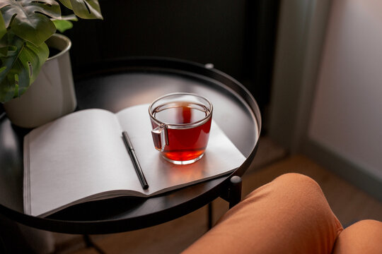woman hand with cup of tea and notebook