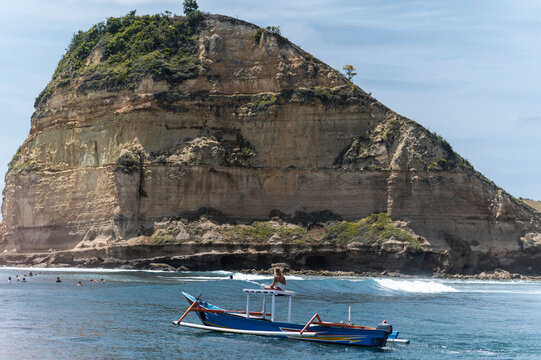Traveling woman watching surfers from a boat