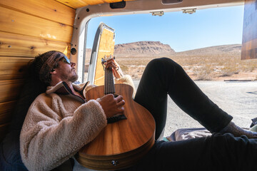 Man playing his guitar in camper van