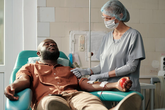 Medical Worker Using Tourniquet On Mans Arm