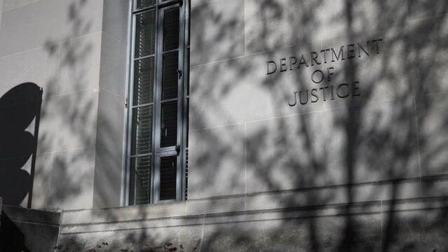 Department of Justice sign on building entrance in Washington, DC.