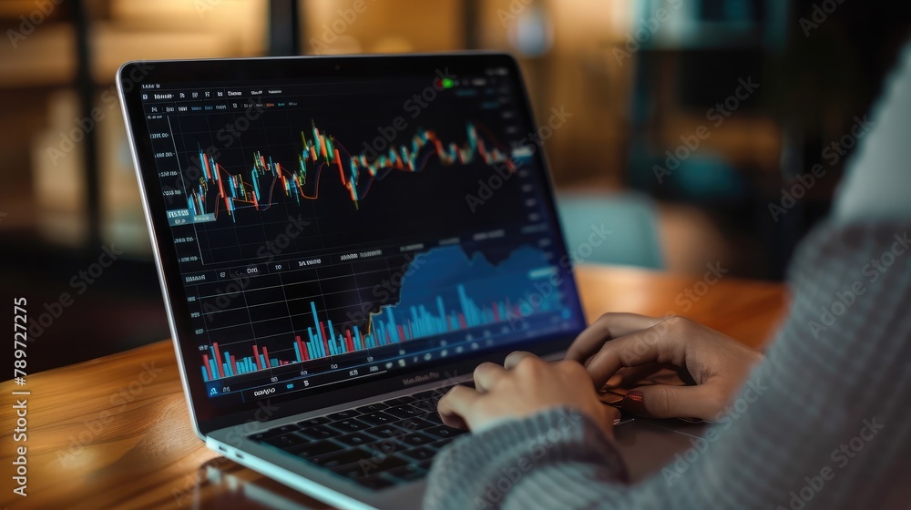 Poster trader monitors stock performance on a laptop screen, leveraging technology for precision timing in 