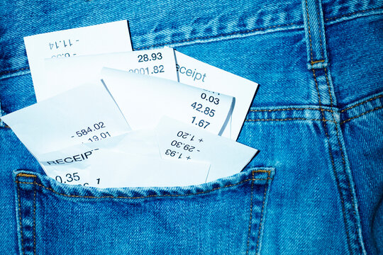 Classic blue jeans and paper receipts in a pocket with hard flashlight