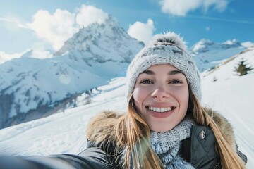 Fototapeta na wymiar smiling young woman taking selfie against snowy mountain landscape winter sports portrait