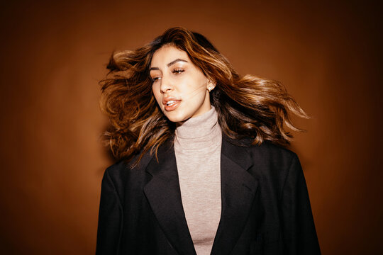 Young woman with flying hair in studio