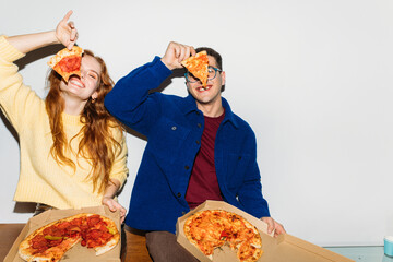 Couple posing with pizza slices
