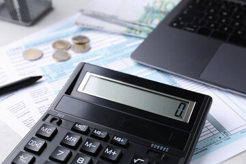 Tax accounting. Calculator, documents, laptop and money on table, closeup