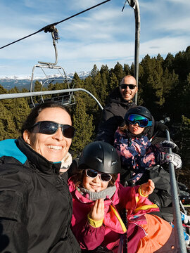 Happy Family Enjoying Ski Lift Adventure Together. UCG travel
