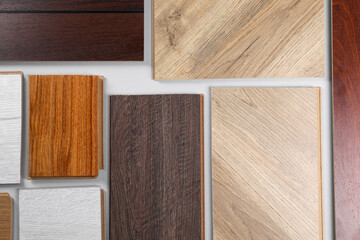 Different samples of wooden flooring on white background, flat lay