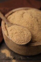 Dietary fiber. Psyllium husk powder in bowl and spoon on table, closeup