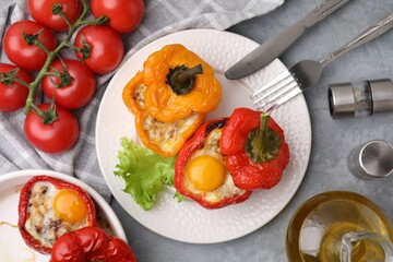 Delicious stuffed peppers with egg served on grey textured table, flat lay