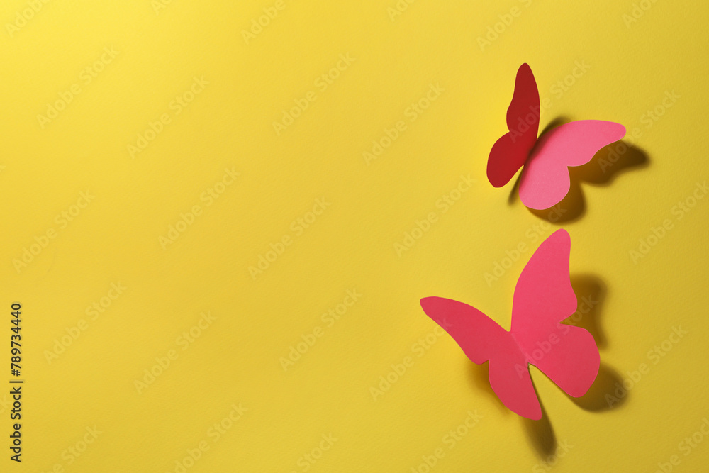 Sticker Bright pink paper butterflies on yellow background