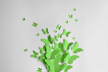 Bright green paper butterflies on white wall