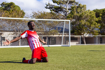 African American young male athlete celebrating on soccer field outdoors