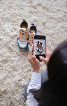 Crop of Woman taking picture of shoes to sell online