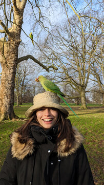 UGC young woman with parakeet on head