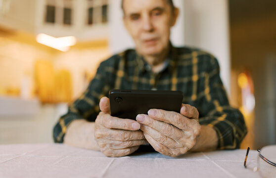 Senior man using modern digital tablet at home for video call
