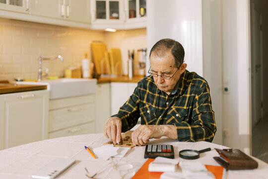 Senior man counting the money and making calculation 