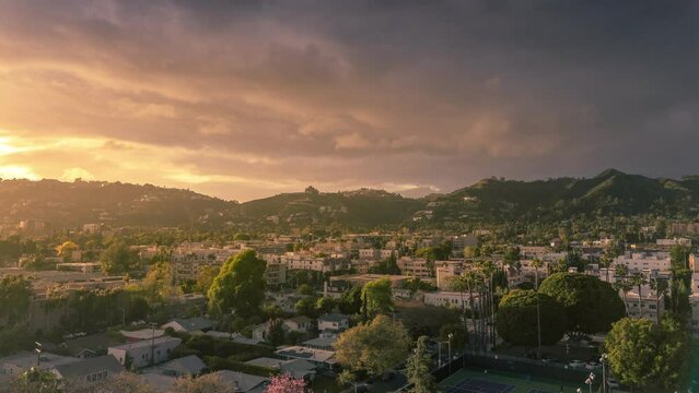 Hollywood, Los Angeles cityscape at sunset during golden hour, aerial hyperlapse view establishing shot.
