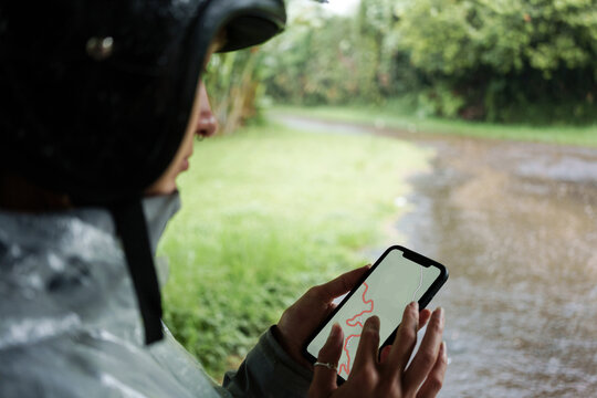Motorcyclist Using Smartphone Navigation in Rain