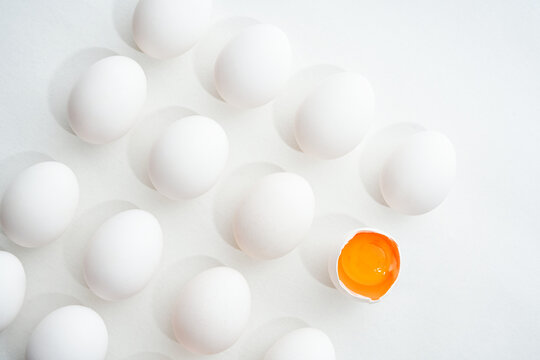 Whole and Cracked Eggs on White Background