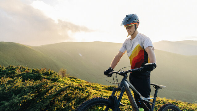 Portrait in mountains.
Man have rest after rides on his bike.
