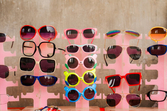 Vibrant sunglasses of different shape on pink background 