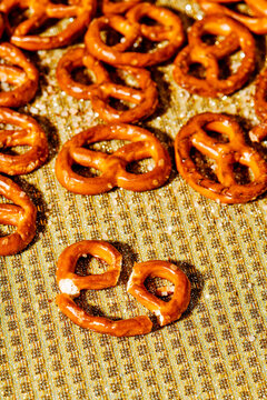 broken hard mini pretzel on a golden surface