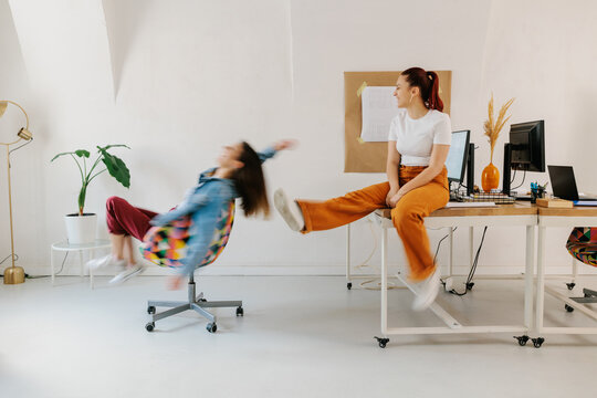 Two young female generation z having fun in office 