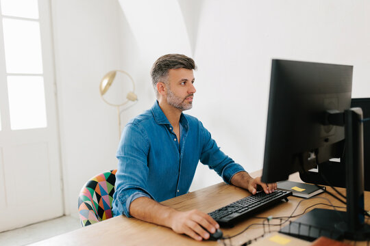 Portrait of a man using desktop computer in modern office 