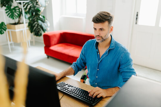 Portrait of a man using desktop computer in modern office 