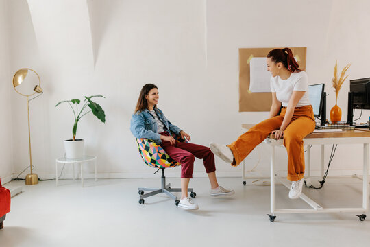 Two young female generation z having fun in office 