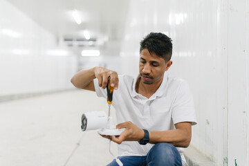 Focused man installing CCTC camera in building