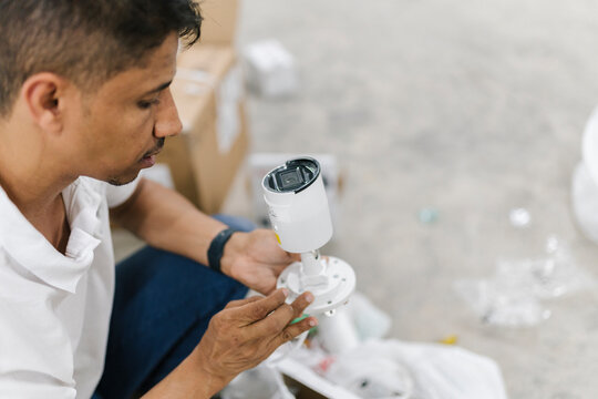 Manual worker installing CCTV camera at workspace