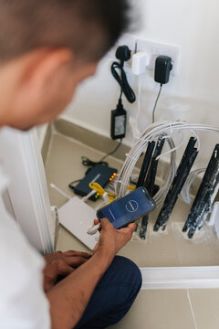 Man using smartphone while installing security cameras