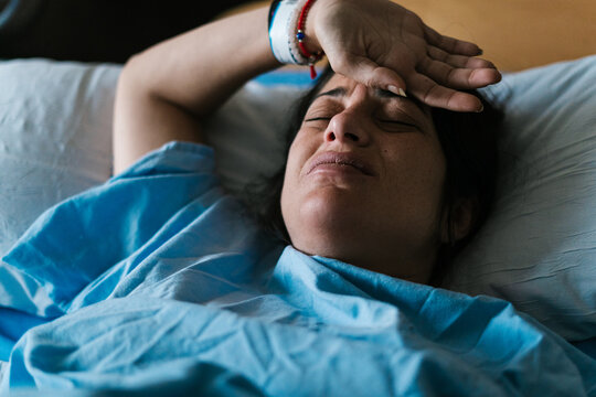 Pregnant woman in labor pains lying in hospital bed