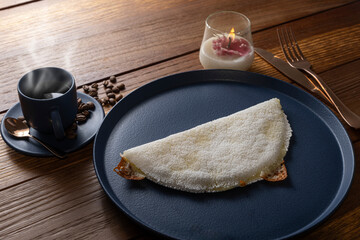 Low key_Melted mozzarella cheese tapioca, next to a cup of black coffee. Traditional Brazilian food_10.