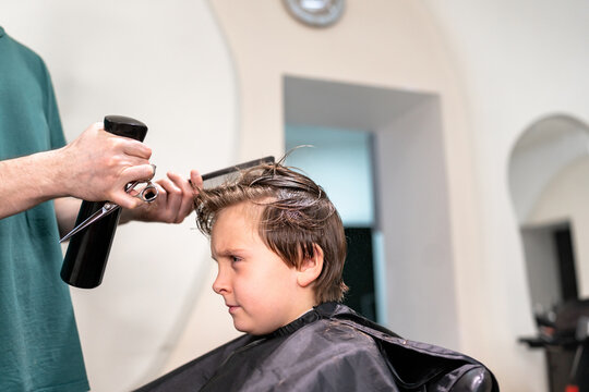 Barber with giving  boy  haircut