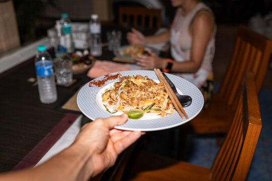 Person holding plate of Pad Thai.