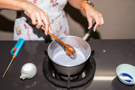 Close-up of a woman cooking in a pot.