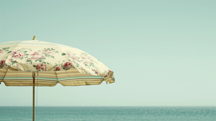 Retro vintage pretty yellow floral flower beach umbrella parasol on sand sunny summer beach sea waves cloud sky earthy natural color vacation relaxation seaside coast resort ocean vibes summer holiday