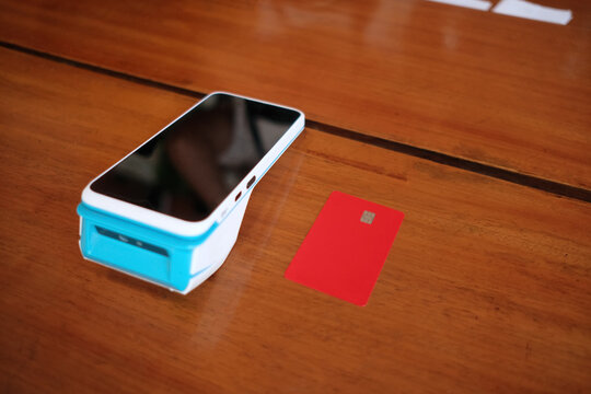 pos terminal and credit card on a table