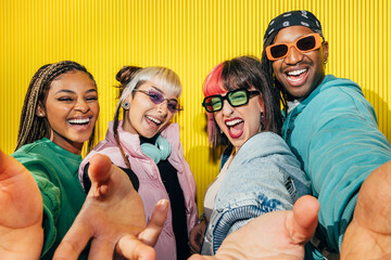 Cheerful young friends taking a group selfie together
