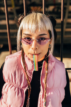 Trendy young woman with candy in urban setting